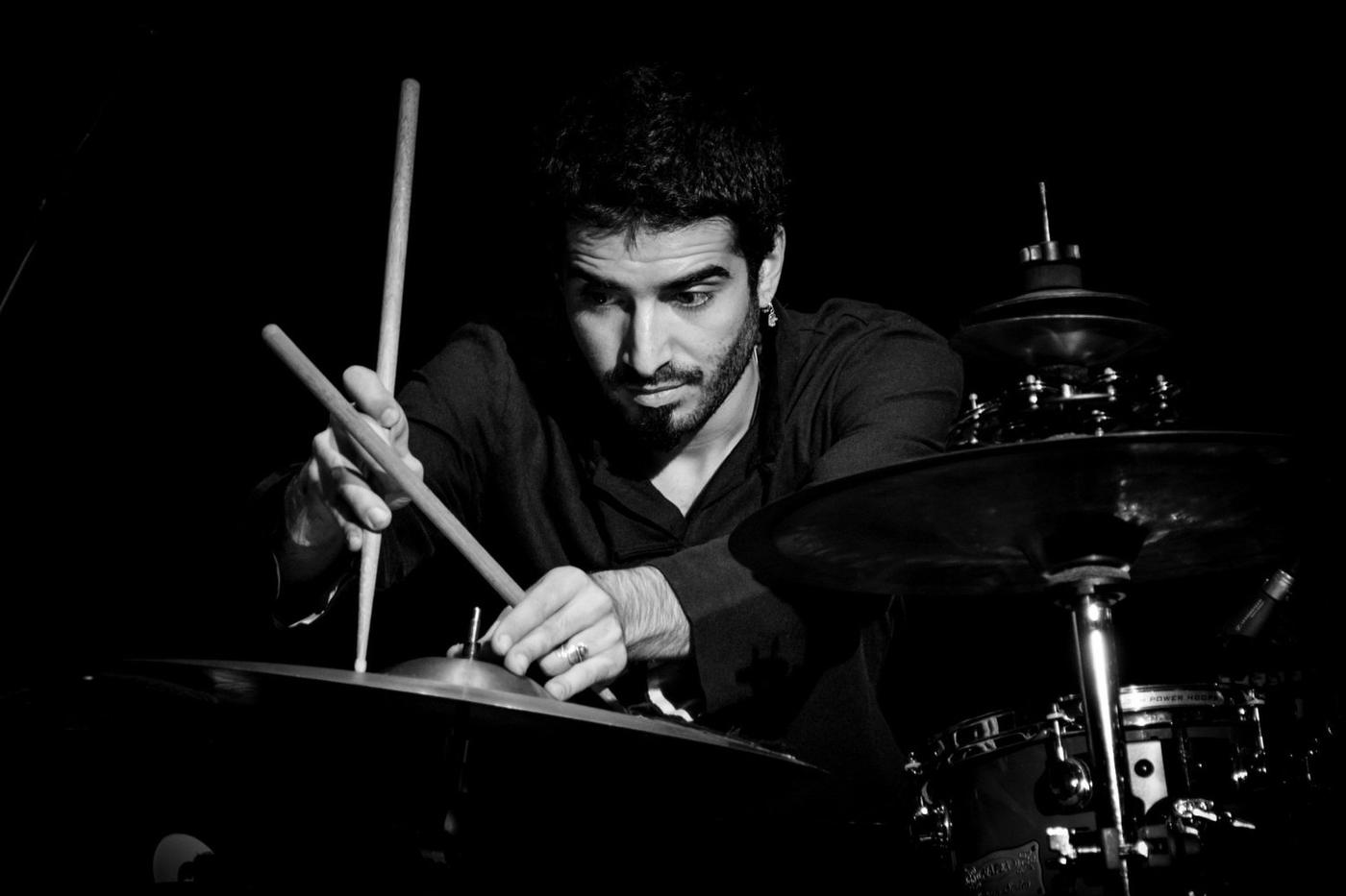 Ravindra alla batteria con le bacchette, in bianco e nero