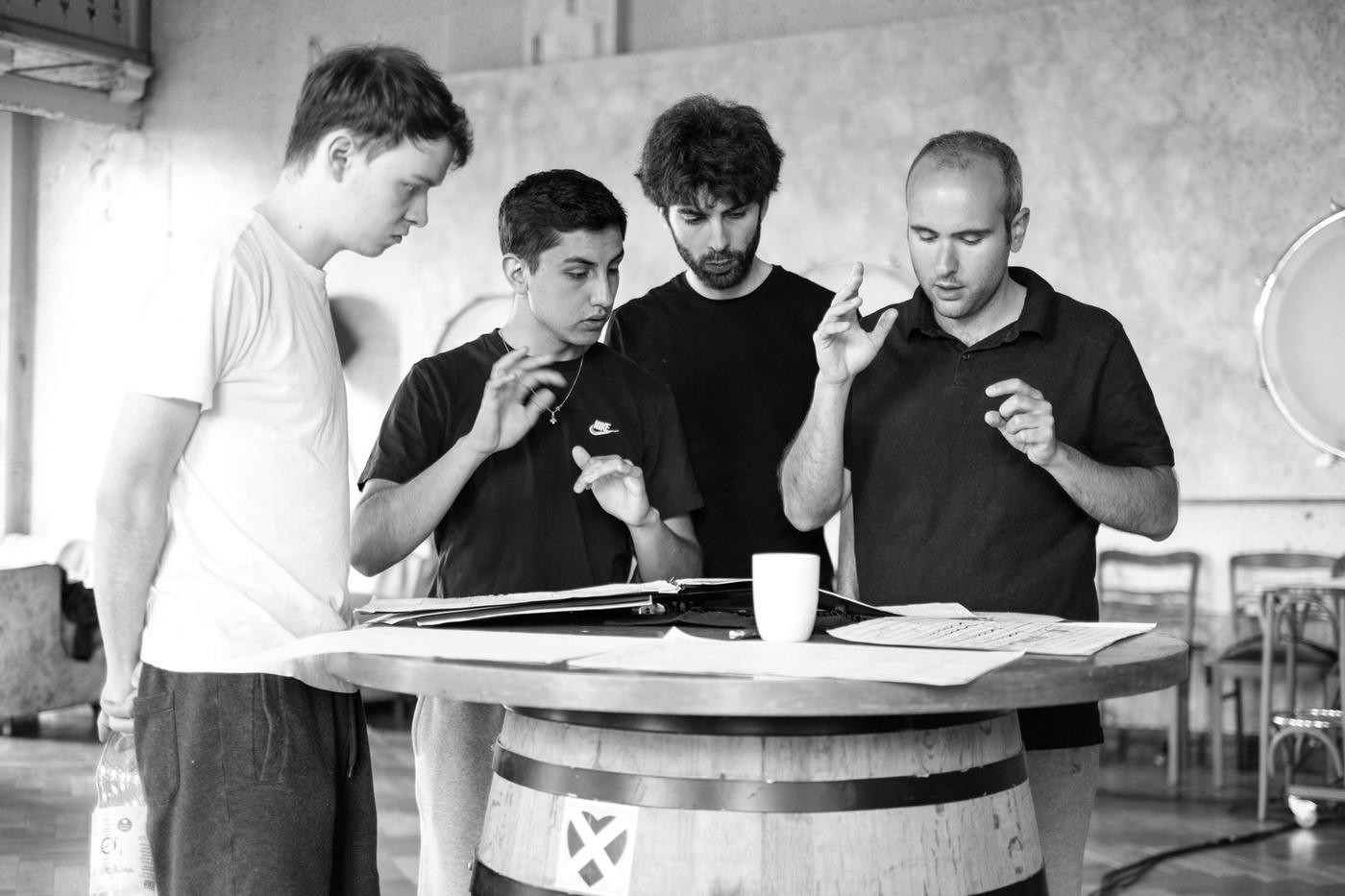 Prove: quattro musicisti studiano la partitura intorno a una botte